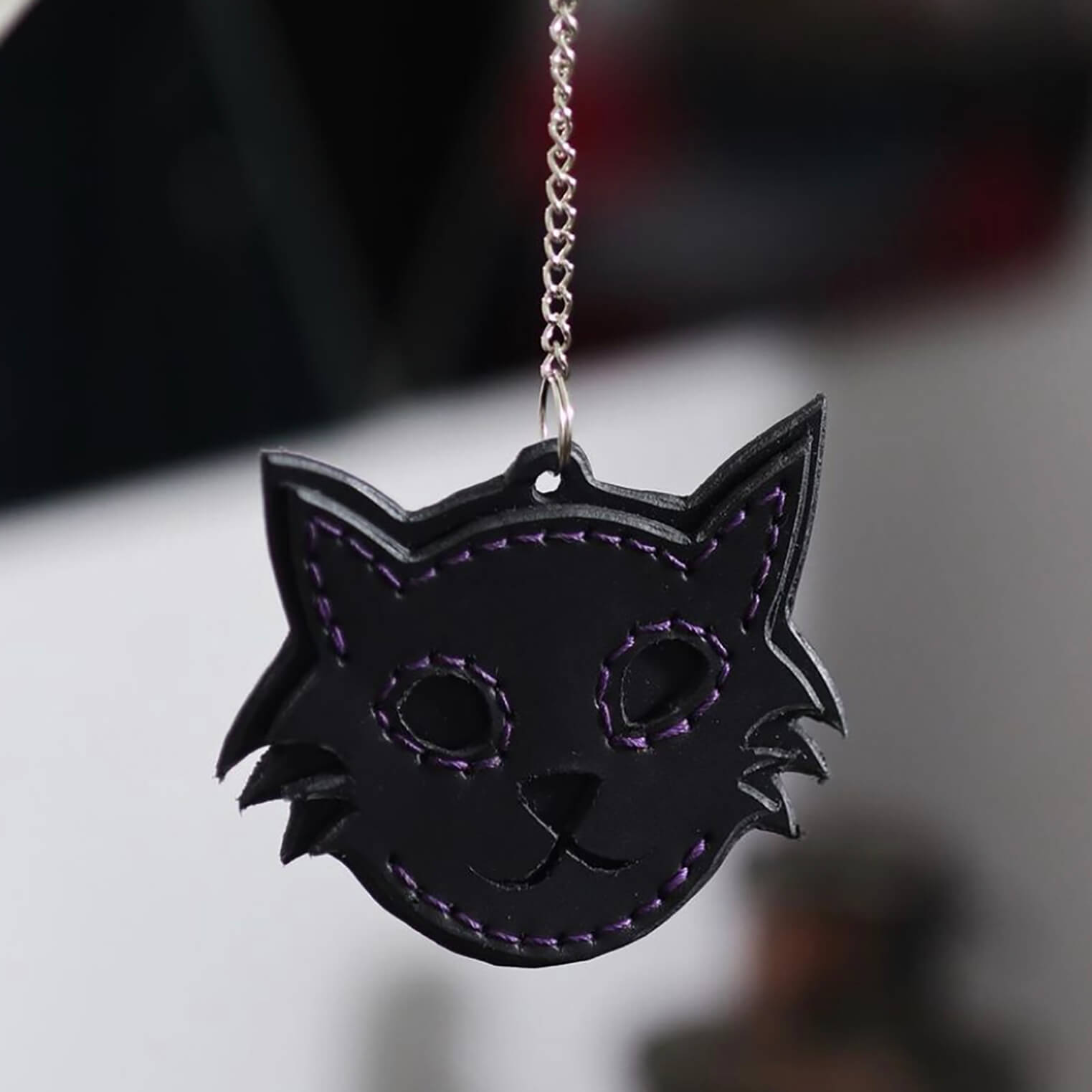 Llavero artesanal en forma de gato hecho en cuero marrón.